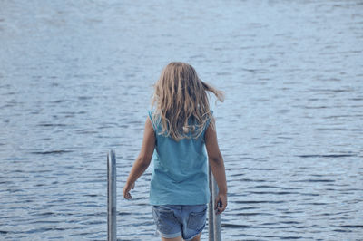 Rear view of girl standing in sea