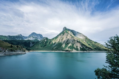 Scenic view of lake by mountains against sky