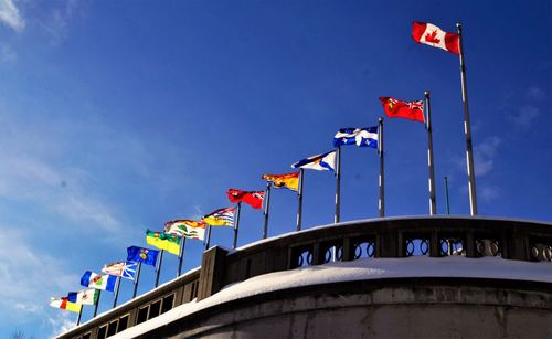 Low angle view of flags against blue sky