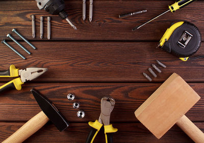 Tools worker, hammer, screwdriver, pliers on a wooden background, top view