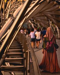 Rear view of people walking on railway station platform