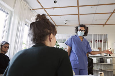 Doctor talking to patients in waiting room