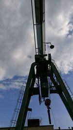 Low angle view of suspension bridge against cloudy sky