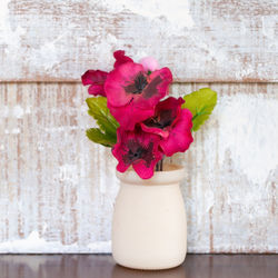 Close-up of pink rose flower vase on table