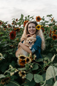 Portrait of smiling young woman against plants