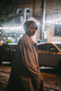 Young man looking at illuminated city