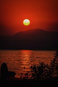 Scenic view of lake against orange sky