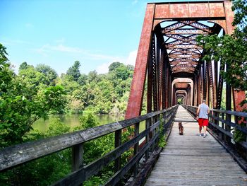 Rear view of woman walking on footbridge