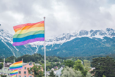 Rainbow flags against mountain during winter