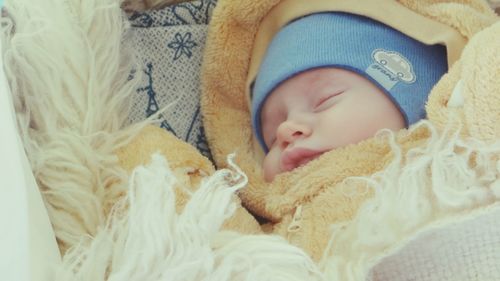 Close-up of baby sleeping in bed