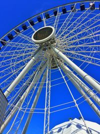 Low angle view of ferris wheel against clear blue sky