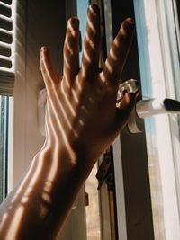 Close-up of hand touching window in building