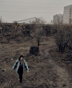 Full length of woman standing on field against sky