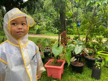 Portrait of boy standing against plants