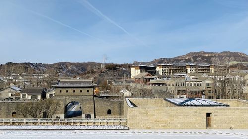 Houses in town against sky during winter