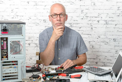 Portrait of businessman sitting at desk in office