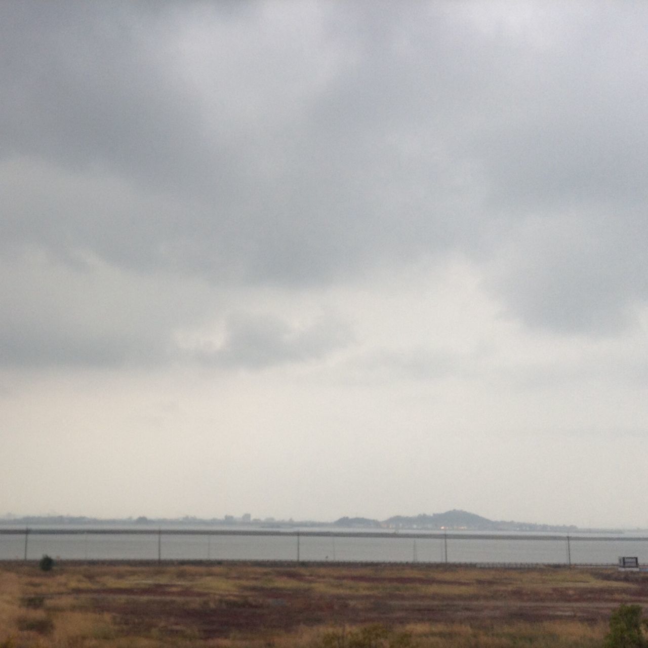 sky, landscape, tranquil scene, cloud - sky, field, tranquility, cloudy, scenics, nature, beauty in nature, cloud, weather, grass, horizon over land, overcast, day, rural scene, non-urban scene, outdoors, no people