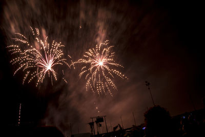 Low angle view of firework display at night