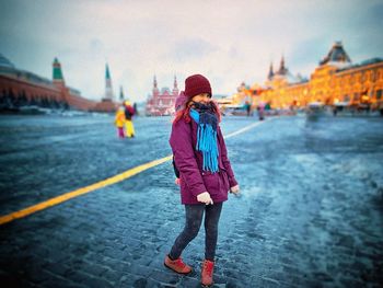 Rear view of woman with umbrella walking in city