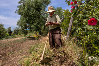 Full length of man wearing hat standing against plants