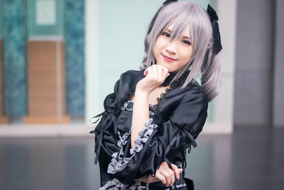 Portrait of smiling woman in costume standing on floor