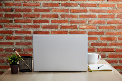 Close-up of coffee cup on table against wall