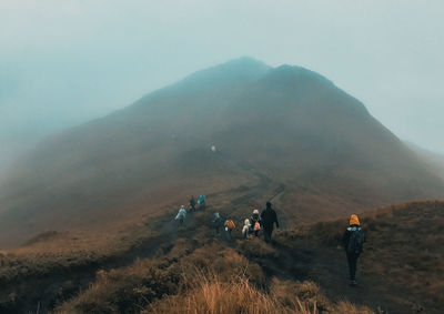 People on mountain road against sky