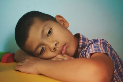 Portrait of cute boy lying on bed at home