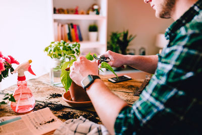 Midsection of man holding flowers on table