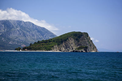 Scenic view of sea and mountains against sky