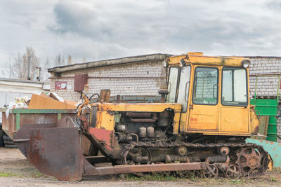 Abandoned construction machinery on land against sky