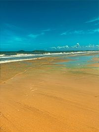 Scenic view of beach against blue sky