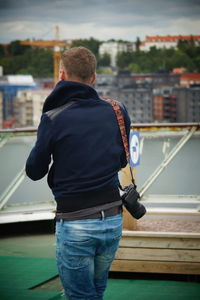 Rear view of man standing by railing