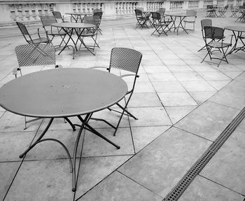 Empty chairs and tables at sidewalk cafe