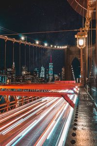 Light trails on bridge in city at night