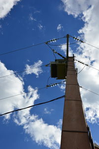 Low angle view of telephone pole against blue sky