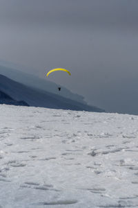 People paragliding over mountain against sky