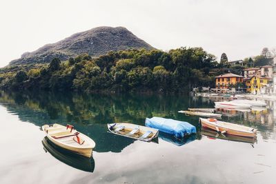 Boats moored on lake against sky