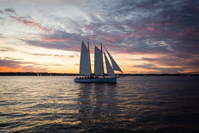 Sailboat sailing on sea against sky during sunset