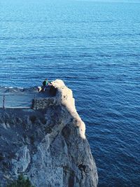 High angle view of man on rock by sea