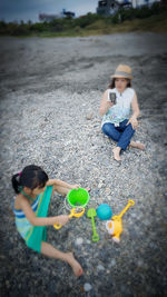 Boy playing with children sitting outdoors