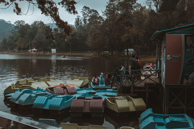 People in lake against trees