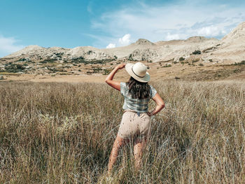 Woman wearing hat on field against sky