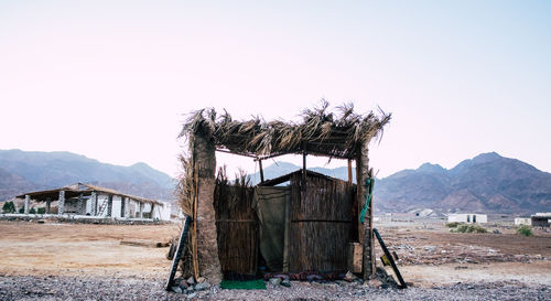 Old wooden house on field against sky