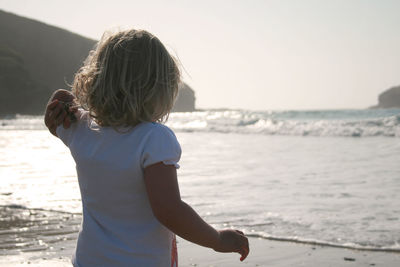 Rear view of girl looking at sea shore