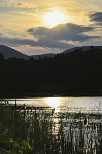 Scenic view of lake against sky during sunset