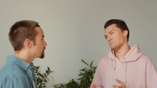 Smiling gay couple laughing at home