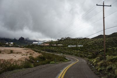 Country road in arizona contains against overcast sky