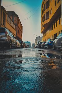 Wet city street against sky