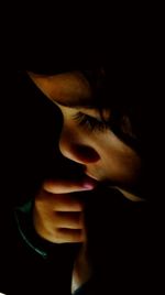 Close-up of young woman over black background